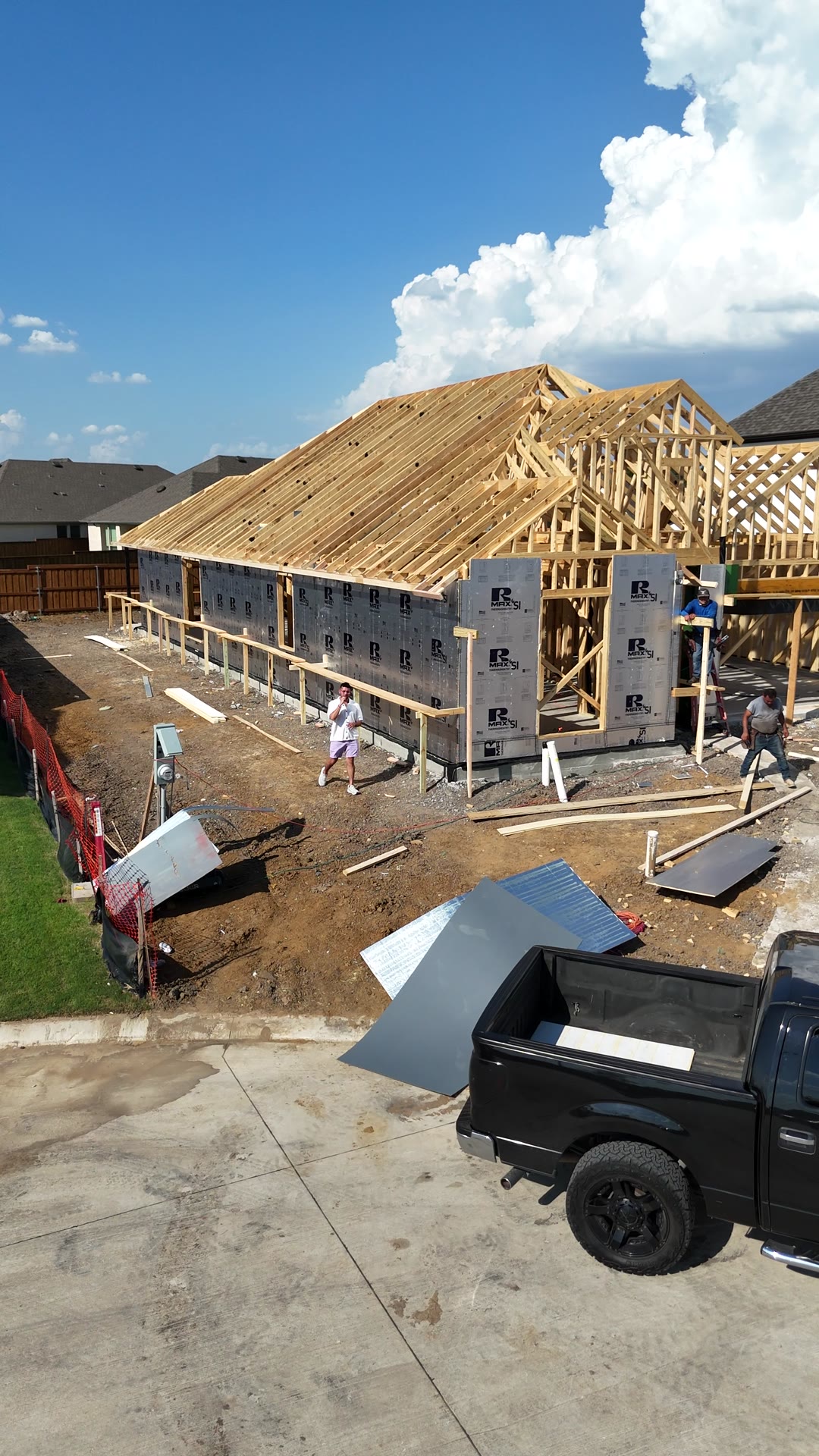 The framed home from the street side, with the crew on site